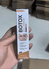 OUHOE Bee Venom Botox Wrinkle Cream in a jar, showing the cream's smooth texture and packaging for anti-aging skincare.